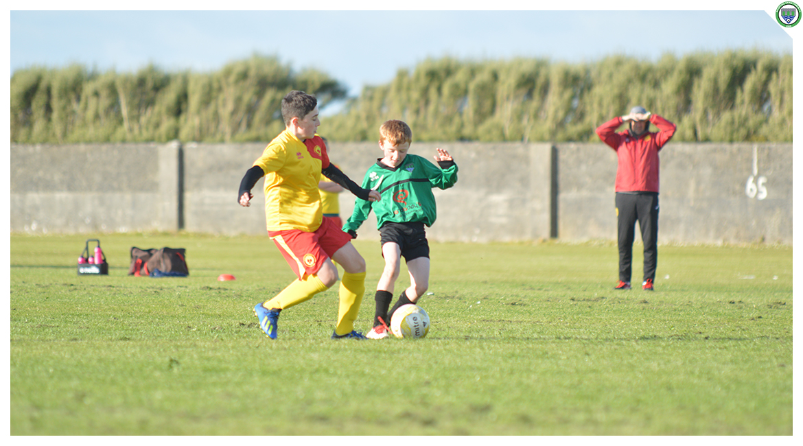 Darren O'Brien tries to retain possession whilst coming under pressure from an Avenue United couterpart in the U12 game between Sporting Ennistymon Football Club and Avenue United Football Club. Game played in Lahinch Sportsfield on the 11th of June 2019.